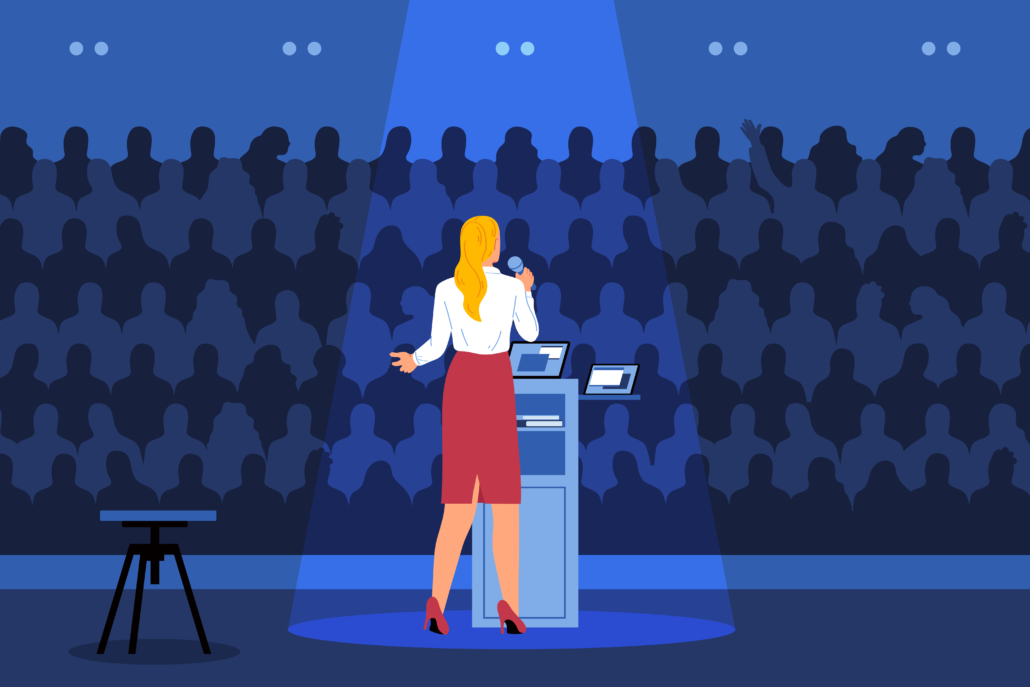 A female speaker at a podium presenting to an audience, representing professional engagement in paid training contracts.