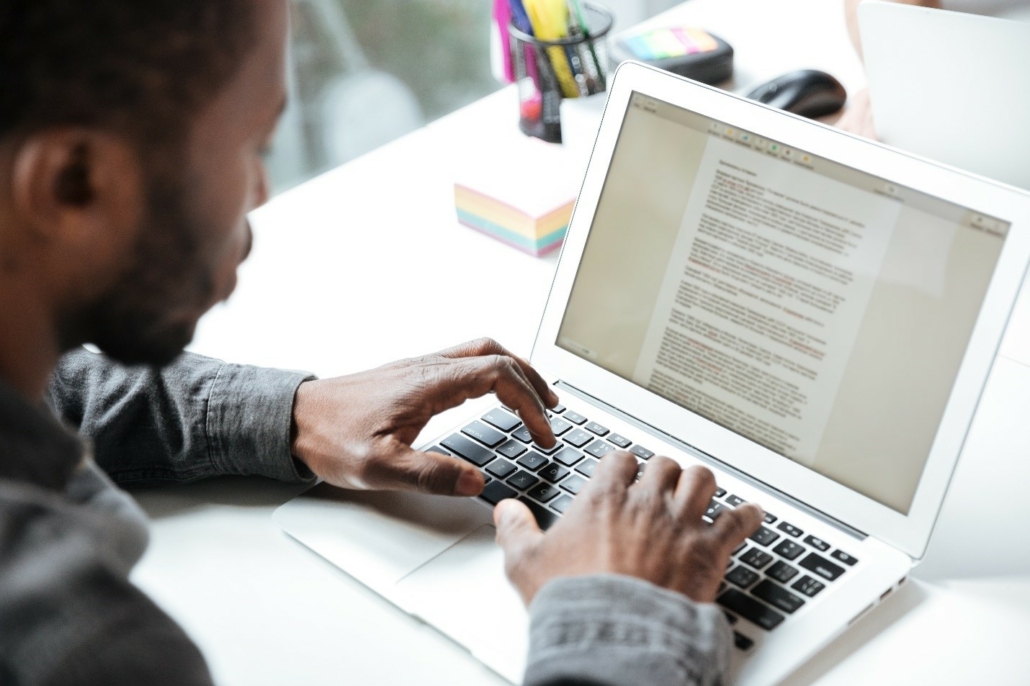 A person typing an abstract on their laptop