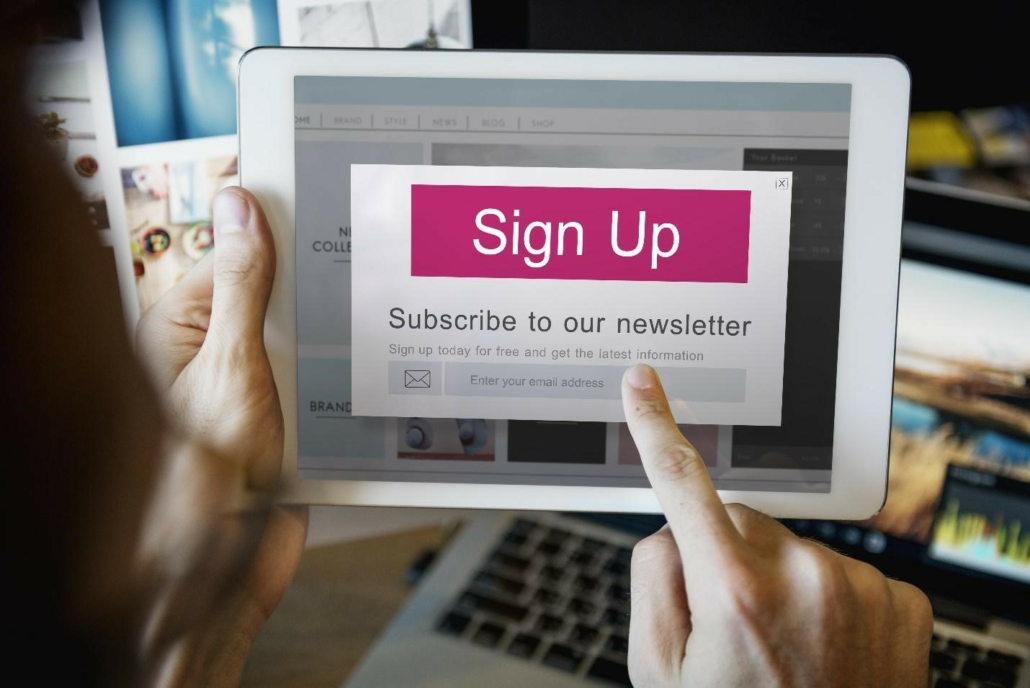 A person using a tablet to sign up for a newsletter, highlighting the importance of SEO best practices for newsletters.