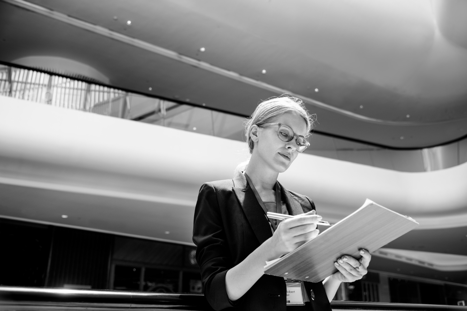 A woman reviewing a book proposal on her clipboard.