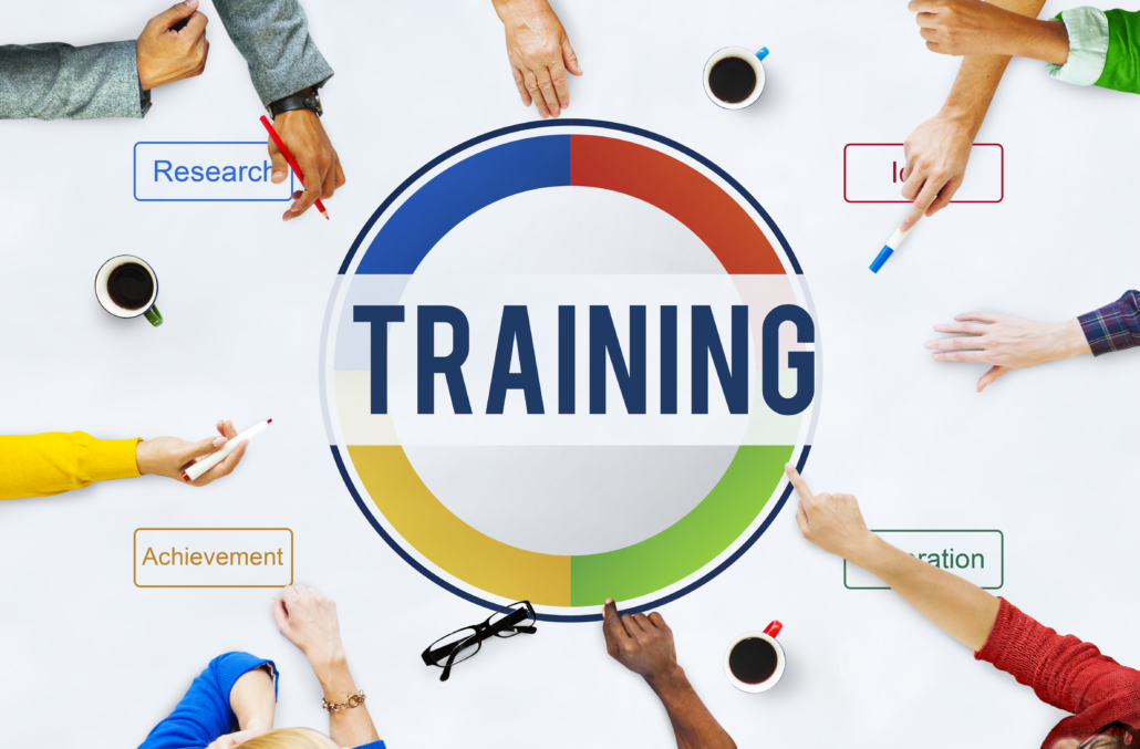 Individuals collaboratively engaging in a training development strategy session surrounding the central word "TRAINING."