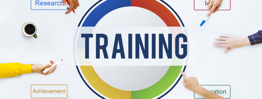 A group of diverse individuals collaboratively engaging in a training development strategy session, with keywords such as "Research," "Achievement," and "Collaboration" surrounding the central word "TRAINING.